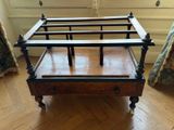 a wooden bed with a wooden frame on wheels on a hard wood floor