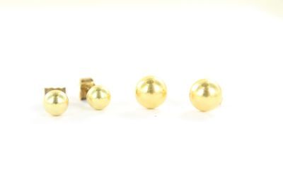une paire de boucles d'oreilles en or sur fond blanc