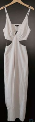 a white dress hanging on a hanger on a black wall