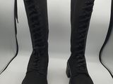 pair of black boots with laces on them sitting in front of a lightbox