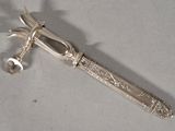 a silver knife that is laying on a table