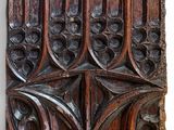 an old wooden panel with a design of leaves and flowers on it