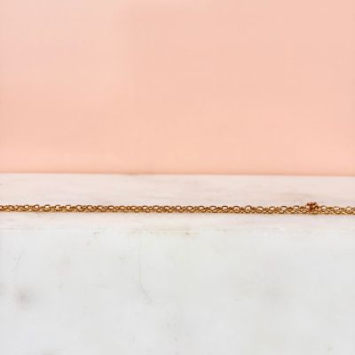 a close up of a gold chain on a marble surface