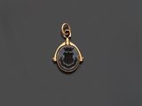 un pendentif plaqué or orné d'un visage en noir et blanc