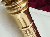 a gold colored object on a white sheet of paper