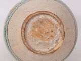 a white bowl with a brown rim on a white surface