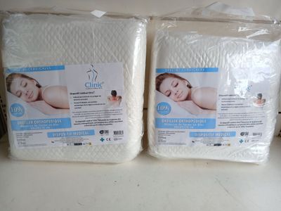 two packs of white mattress covers sitting on top of a counter
