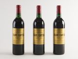three bottles of wine sitting on top of a white table