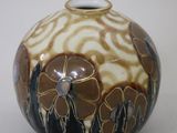 a brown and white vase sitting on a white surface