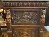 une armoire ancienne en bois, ornée de sculptures raffinées sur le dessus