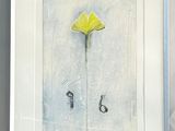 a picture of a painting of a yellow flower in a white frame