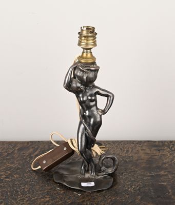 une statue représentant une femme tenant une lampe posée sur une table