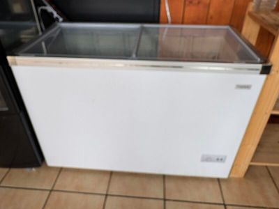 un petit réfrigérateur avec une porte vitrée dans une cuisine