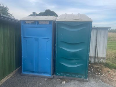two portable toilets in a row next to each other