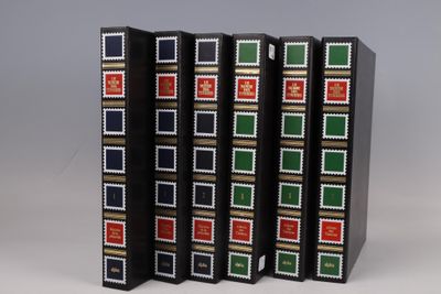 three books are lined up in a row on a gray surface