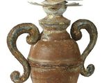 un oiseau perché sur un vase posé sur un socle