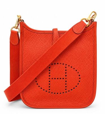 a red cross body bag with the letter h on it