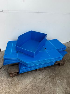 a pile of blue plastic bins sitting on top of a wooden pallet