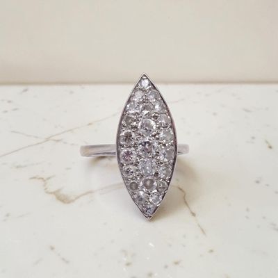 un gros plan d'une bague en diamant posée sur une surface en marbre