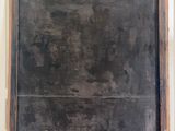 an old blackboard on a wooden shelf in a room