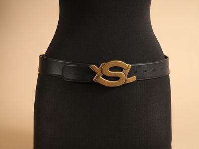 un gros plan sur le torse d'un mannequin portant une ceinture noire à boucle dorée