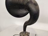 an old fashioned black gramphone sitting on a white table