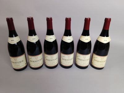 six bouteilles de vin sont alignées sur une table