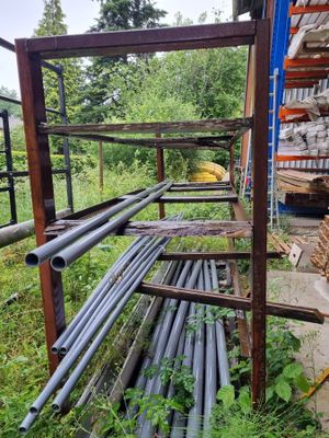 un rack rempli de tuyaux métalliques dans une cour