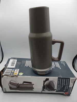 a coffee cup sitting on top of a box next to a camera