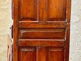 a tall wooden cabinet with a door on top of it