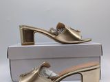a pair of gold shoes sitting on top of a box