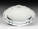 une assiette en argent ornée d'un motif floral sur le bord