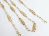 a close up of a group of gold chains on a white surface