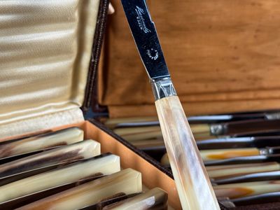 Quelqu'un tient un couteau dans un étui contenant plusieurs couteaux