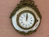 a clock hanging on the wall with a ribbon around it