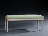 an upholstered bench with a green upholstered cushion