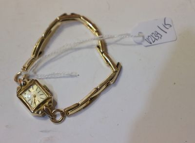 un bracelet en or avec une montre, posé sur une table