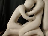 a sculpture of two people hugging each other on a table