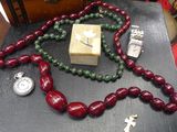a necklace and a watch on a table next to a box
