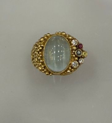une image représentant une bague en or sertie d'une pierre bleue entourée de diamants