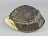a metal mesh hat that is on a white surface