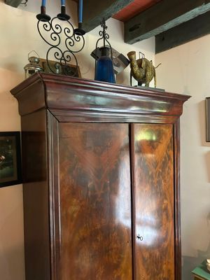 a tall wooden cabinet in the corner of a room