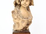 une image représentant une statue d'enfant posée sur un socle en bois