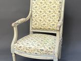 a white chair with a floral upholstered back and arms