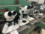 trois microscopes posés sur une table