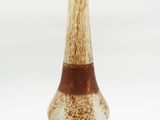 a brown and white vase sitting on a white surface