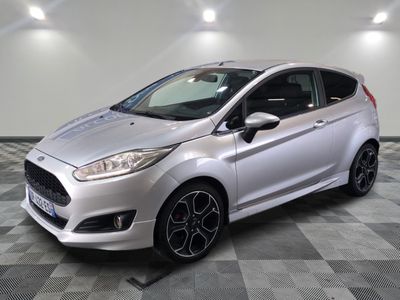 a silver ford fiesta parked on a checkered floor in a showroom
