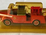 a red toy truck with a red cab on a gold base