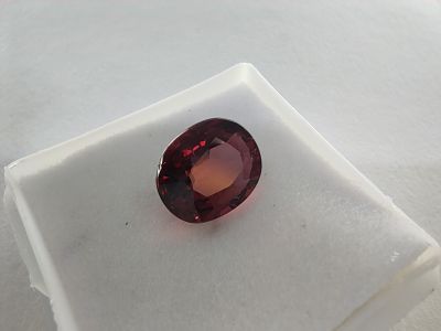 un gros plan d'une pierre de grenat rouge sur une surface blanche