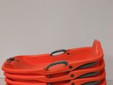 four orange plastic trays with handles and handles on a white surface